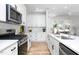Stylish kitchen with stainless appliances, subway tile backsplash, white cabinets and hardwood flooring at 1514 W Knox St, Durham, NC 27705