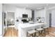 Open kitchen with an island, white cabinetry, stainless steel appliances, and hardwood floors at 1514 W Knox St, Durham, NC 27705