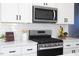 Modern kitchen featuring stainless steel appliances, white cabinets, and subway tile backsplash at 1514 W Knox St, Durham, NC 27705