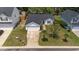 Aerial view of the home's front exterior, driveway, and landscaped yard at 1725 E Honey Springs Ave, Fuquay Varina, NC 27526