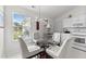 Bright eat-in kitchen with white cabinetry and a glass table with four upholstered chairs beneath modern lighting at 1725 E Honey Springs Ave, Fuquay Varina, NC 27526