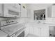 A well-lit kitchen features a white stove and microwave, plenty of counter space, and bright white cabinets at 1725 E Honey Springs Ave, Fuquay Varina, NC 27526