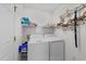 Functional laundry room equipped with a washer, dryer, shelving and charming decorative accents at 1725 E Honey Springs Ave, Fuquay Varina, NC 27526