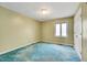 Simple bedroom with blue carpet, green walls, and a window providing natural light at 1732 Farmington Rd, Rocky Mount, NC 27801