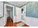 Hallway with hardwood floors and wainscoting leads to the kitchen and other rooms at 1732 Farmington Rd, Rocky Mount, NC 27801
