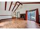 Living room showcases exposed beams, a brick fireplace, and sliding glass doors offering backyard access at 1732 Farmington Rd, Rocky Mount, NC 27801