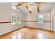 Bright living room with wood-look floors, and a ceiling fan, and many windows letting in natural light at 1732 Farmington Rd, Rocky Mount, NC 27801