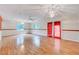 Spacious living room with wood-look floors, ceiling fan, and natural light from windows and glass door at 1732 Farmington Rd, Rocky Mount, NC 27801