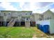 Backyard view of townhomes with individual decks and staircase access from green lawn at 1806 Stroll Cir, Fuquay Varina, NC 27526