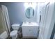 This bathroom showcases a toilet, vanity with a round mirror, and shower with curtain at 1806 Stroll Cir, Fuquay Varina, NC 27526