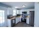 Well-lit kitchen featuring stainless steel appliances, stylish cabinets, and butcher block countertops at 1806 Stroll Cir, Fuquay Varina, NC 27526