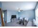 Bright living room with modern furnishings, ceiling fan, and large windows at 1806 Stroll Cir, Fuquay Varina, NC 27526