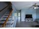 Open-concept living room with staircase, blue walls, and gray flooring at 1806 Stroll Cir, Fuquay Varina, NC 27526