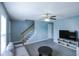 Cozy living room showcasing stairs and modern furniture, including a gray sofa and TV stand at 1806 Stroll Cir, Fuquay Varina, NC 27526