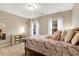 Cozy bedroom with a writing desk near a window, and a queen bed with pillows and stuffed animals at 201 Forbes Rd, Wake Forest, NC 27587