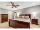 This is a bedroom with neutral paint, ceiling fan, and dark wood furniture. There is a large mirror and two nightstands at 201 Forbes Rd, Wake Forest, NC 27587