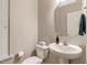 Classic powder room with pedestal sink, hexagon mirror and neutral tones at 201 Forbes Rd, Wake Forest, NC 27587