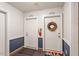 Apartment hallway with white doors, colorful mats and wreaths at 2010 Quaker Lndg # 102, Raleigh, NC 27603