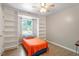Cozy bedroom featuring built-in shelves, wood floors, a ceiling fan, and bright natural light at 2010 Quaker Lndg # 102, Raleigh, NC 27603