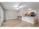 Open concept living room with hardwood floors, ceiling fan, and access to the adjacent kitchen at 2010 Quaker Lndg # 102, Raleigh, NC 27603