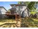 View of the home's backyard with a well-maintained lawn, wooden deck, and access stairs at 203 Kronos Lane, Cary, NC 27513