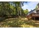 Spacious backyard featuring a lush lawn, mature trees, and a classic wooden fence at 203 Kronos Lane, Cary, NC 27513