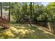 Backyard featuring mature trees, grass, and partial fencing at 203 Kronos Lane, Cary, NC 27513
