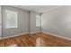 Bright bedroom features wood flooring, neutral walls, and two windows with blinds at 203 Kronos Lane, Cary, NC 27513