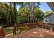 Outdoor wooden deck presents a serene space, surrounded by mature trees and a fenced yard at 203 Kronos Lane, Cary, NC 27513