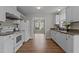 Open kitchen layout with white appliances and cabinets and granite countertops, offering a seamless flow at 203 Kronos Lane, Cary, NC 27513