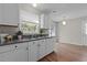 Well-lit kitchen boasts granite counters and white cabinets with modern fixtures at 203 Kronos Lane, Cary, NC 27513