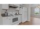 Kitchen with granite countertops, white appliances and cabinetry, adjacent to the dining area at 203 Kronos Lane, Cary, NC 27513