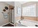 Bathroom showcasing a soaking tub with tile surround and a glass-enclosed shower at 206 Wynngate Dr, Cameron, NC 28326