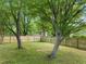 Spacious, fenced backyard with mature trees and green grass, offering privacy and ample space for outdoor activities at 21 Cedar Hill Dr, Durham, NC 27713