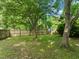 Large, grassy backyard with a wooden privacy fence and mature trees, creating a serene outdoor space at 21 Cedar Hill Dr, Durham, NC 27713