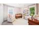 Charming Bedroom with pink floral wallpaper, wooden crib, glider, and bookshelf filled with colorful books at 21 Cedar Hill Dr, Durham, NC 27713