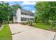 Charming two-story home with black shutters, lush landscaping, and a long driveway under a sunny, partly cloudy sky at 21 Cedar Hill Dr, Durham, NC 27713