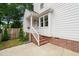 Charming home exterior with brick foundation, white siding, and a covered entrance with stairs at 21 Cedar Hill Dr, Durham, NC 27713
