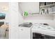 Functional laundry room with white cabinets, shelves, and modern washer and dryer units, offering ample storage at 21 Cedar Hill Dr, Durham, NC 27713