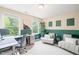 Home office with neutral walls, green accent wall, multiple windows, and seating area; filled with natural light at 21 Cedar Hill Dr, Durham, NC 27713