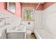 A bathroom features white tile, a white tub, and a single sink at 211 Cool Spring Rd, Durham, NC 27713