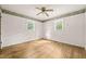 A bright bedroom with hardwood floors featuring two windows and a ceiling fan at 211 Cool Spring Rd, Durham, NC 27713