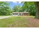 Charming one-story home with a brick exterior, complemented by lush green lawn and mature trees at 211 Cool Spring Rd, Durham, NC 27713