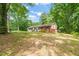 Quaint one-story brick home with blue shutters and a cozy front porch surrounded by mature trees at 211 Cool Spring Rd, Durham, NC 27713