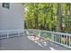 Large back deck with white railings and views of the lush, wooded backyard at 2125 Oakcrest Ct, Raleigh, NC 27612
