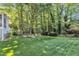 The grassy backyard includes mature trees and a walkway to a secluded area at 2125 Oakcrest Ct, Raleigh, NC 27612