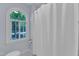Bright bathroom featuring a window with shutters and a classic white shower curtain at 2125 Oakcrest Ct, Raleigh, NC 27612