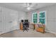 Carpeted bedroom with dual closets, ceiling fan, and a desk with dual computer monitors near a window at 2125 Oakcrest Ct, Raleigh, NC 27612