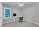 This bedroom features neutral walls and carpet, with a ceiling fan and a window to bring in natural light at 2125 Oakcrest Ct, Raleigh, NC 27612