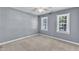 Spacious bedroom with neutral walls and carpet featuring dual windows and a ceiling fan at 2125 Oakcrest Ct, Raleigh, NC 27612